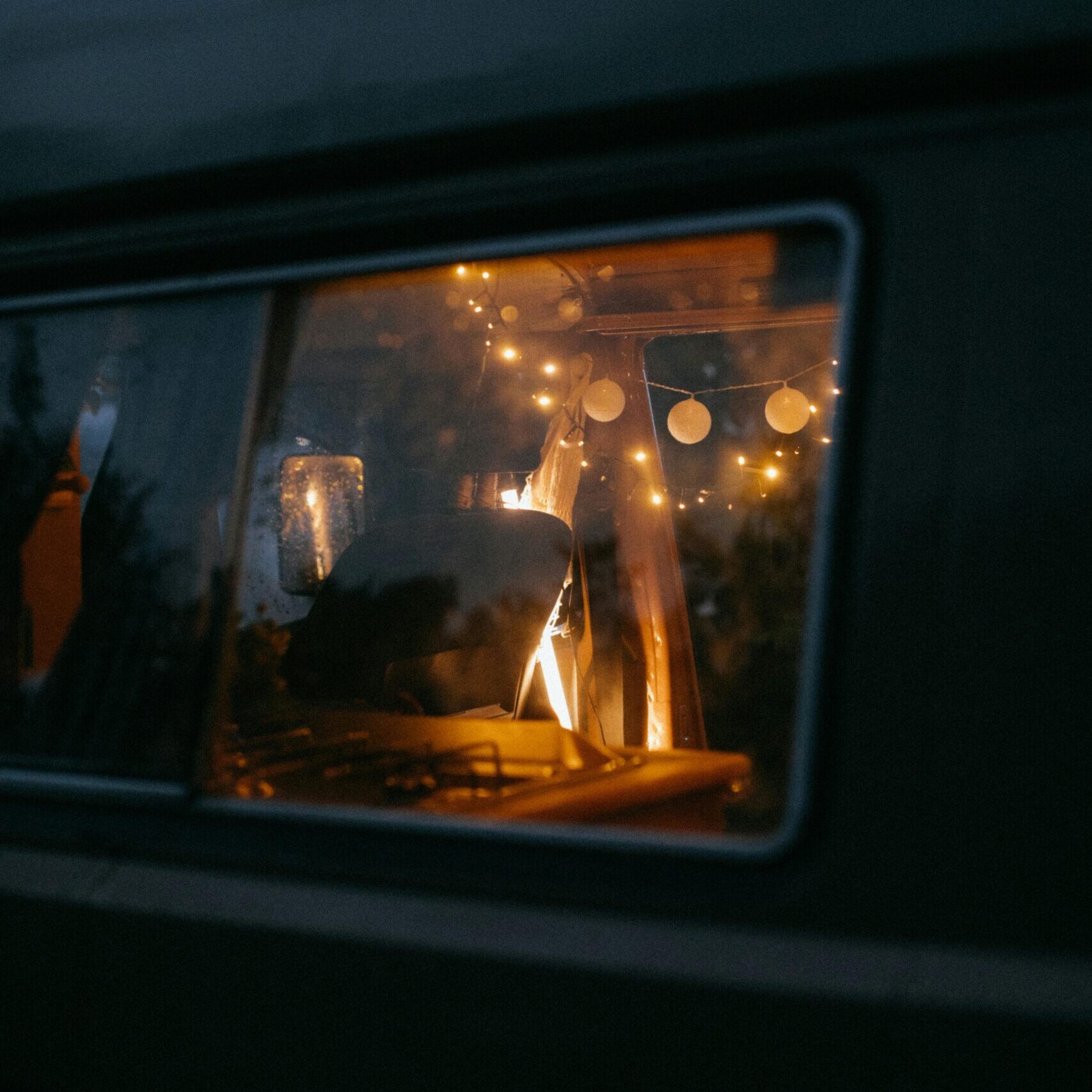 Vue extérieur d'un van autonome en électricité la nuit, éclairé par des ampoules de couleur chaude