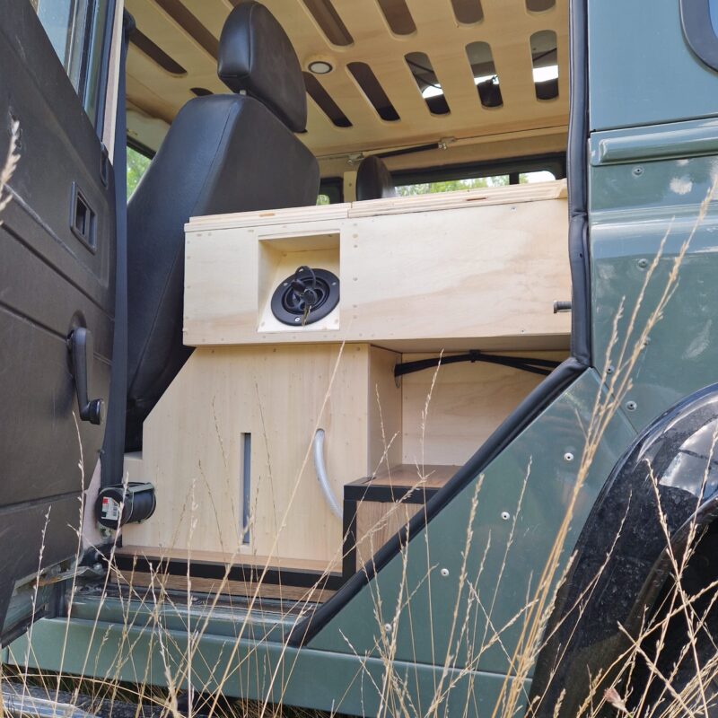 Coupelle de remplissage et niveau du réservoir vue de la porte arrière gauche d'un land rover defender aménagé