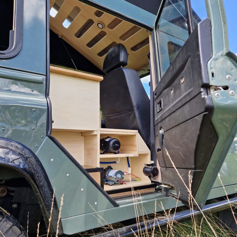 Compartiment plomberie d'un Land Rover defender aménagé par l'atelier La Champ' à Bordeaux