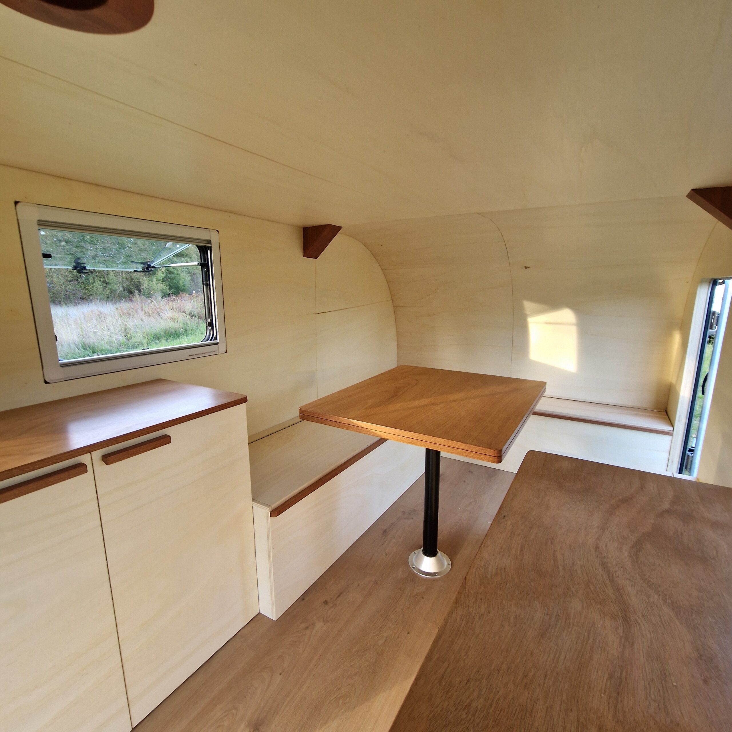 Plans de travail et table escamotable en contreplaqué Okoumé vernis avec chants plaqués dans une remorque aménagée à Bordeaux.